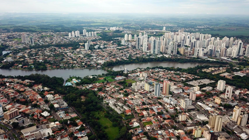 an aerial view of a city with a river running through it, by Ceferí Olivé, flickr, city of the jungle, skyline showing, beto val, tall buildings on the sides