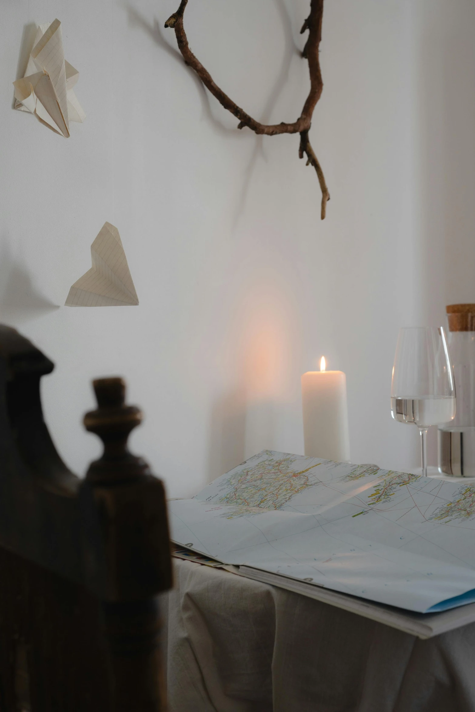 a book sitting on top of a table next to a candle, white room, on the altar, close - up photograph, linen