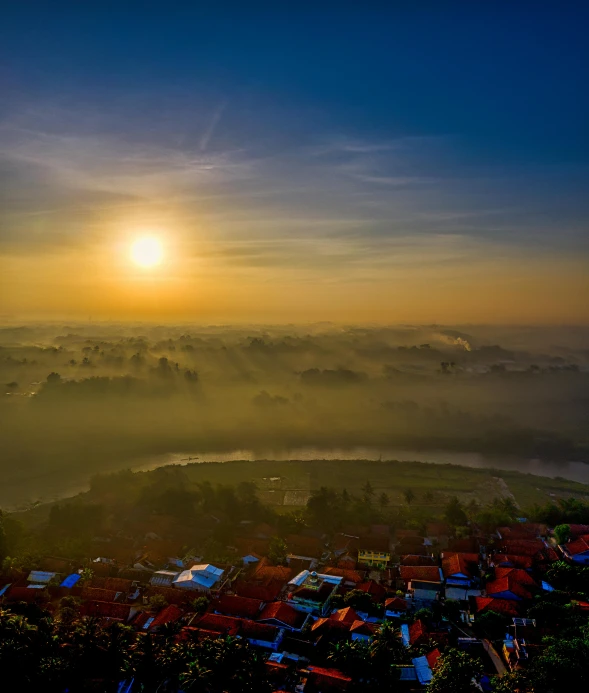 the sun is setting over a small town, by Sebastian Spreng, pexels contest winner, sumatraism, in the bottom there a lot of fog, today\'s featured photograph 4k, wide angle river, high view