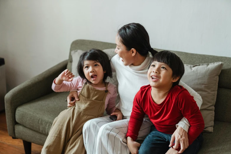 a woman and two children sitting on a couch, pexels contest winner, asian girl, excited, youtube thumbnail, high quality image
