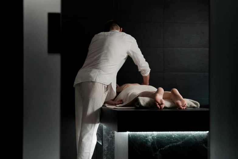 a man standing over a woman laying on a table, luxurious onsens, still photograph