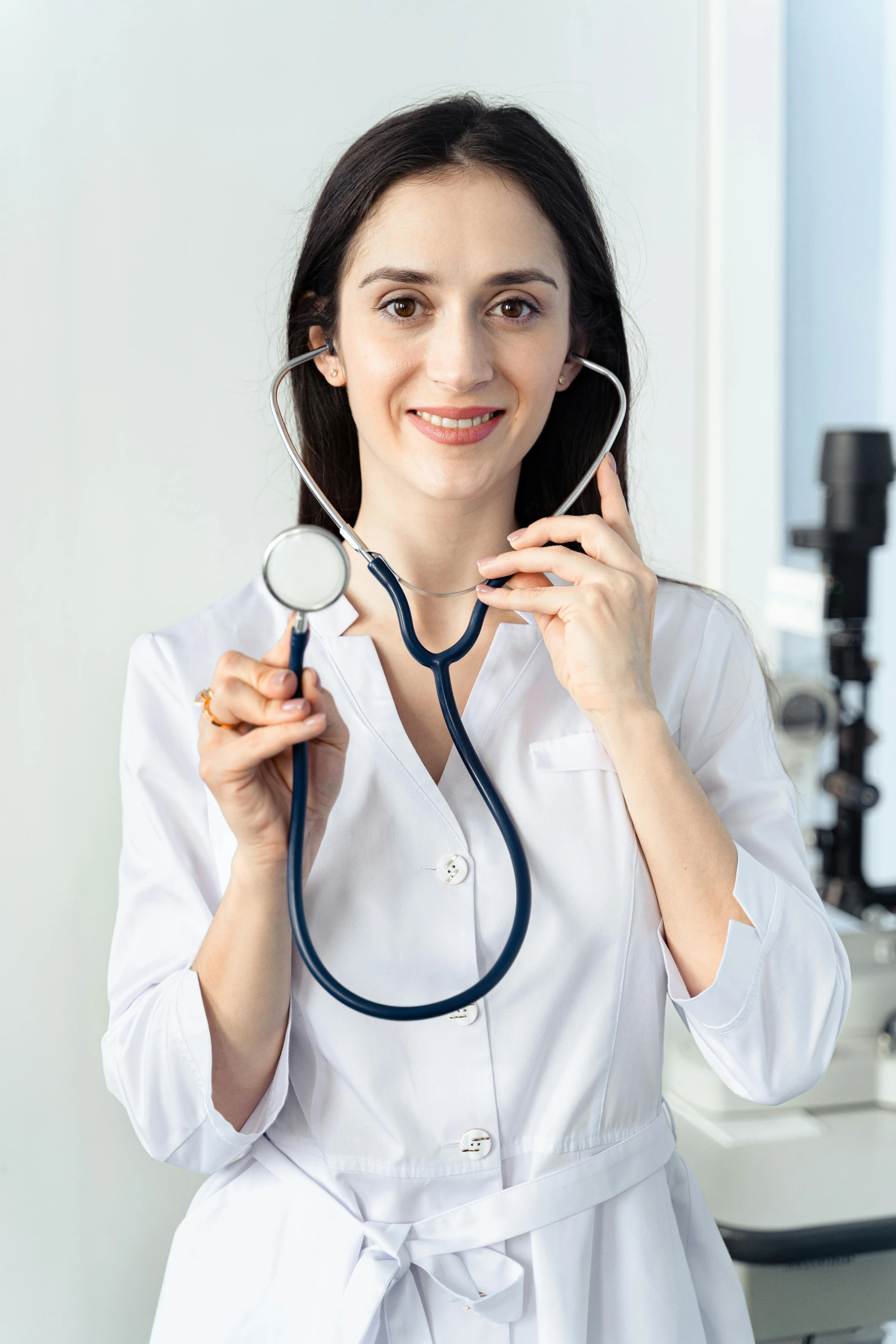 a woman in a white shirt is holding a stethoscope, on a advanced lab, with a white complexion, fine features, promo image