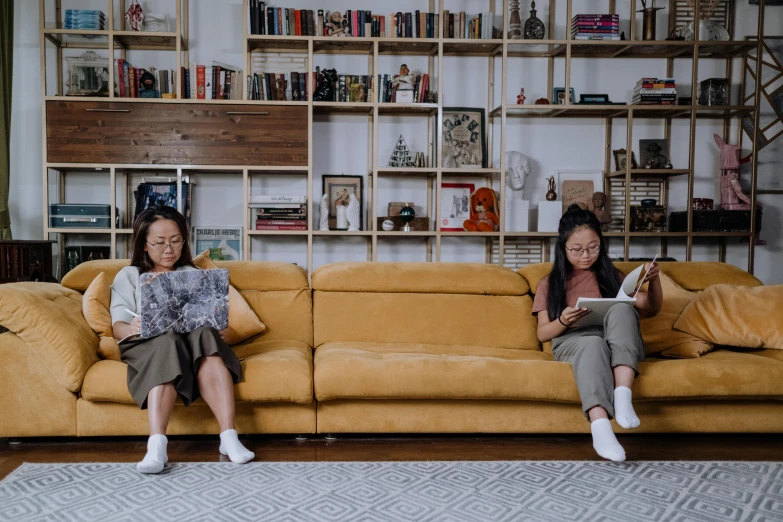 a couple of women sitting on top of a couch, pexels contest winner, maximalism, short bookshelf, avatar image, asian descent, white and yellow scheme