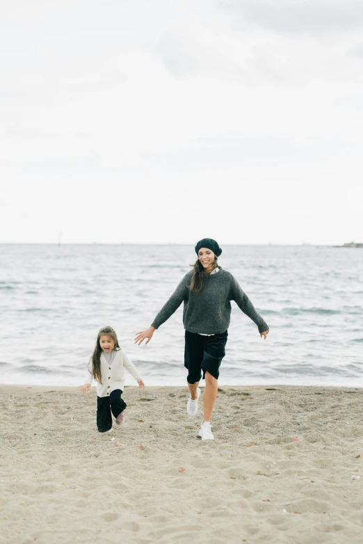 a man and a little girl running on a beach, unsplash, minimalism, black haired girl wearing hoodie, in barcelona, a still of a happy, orelsan