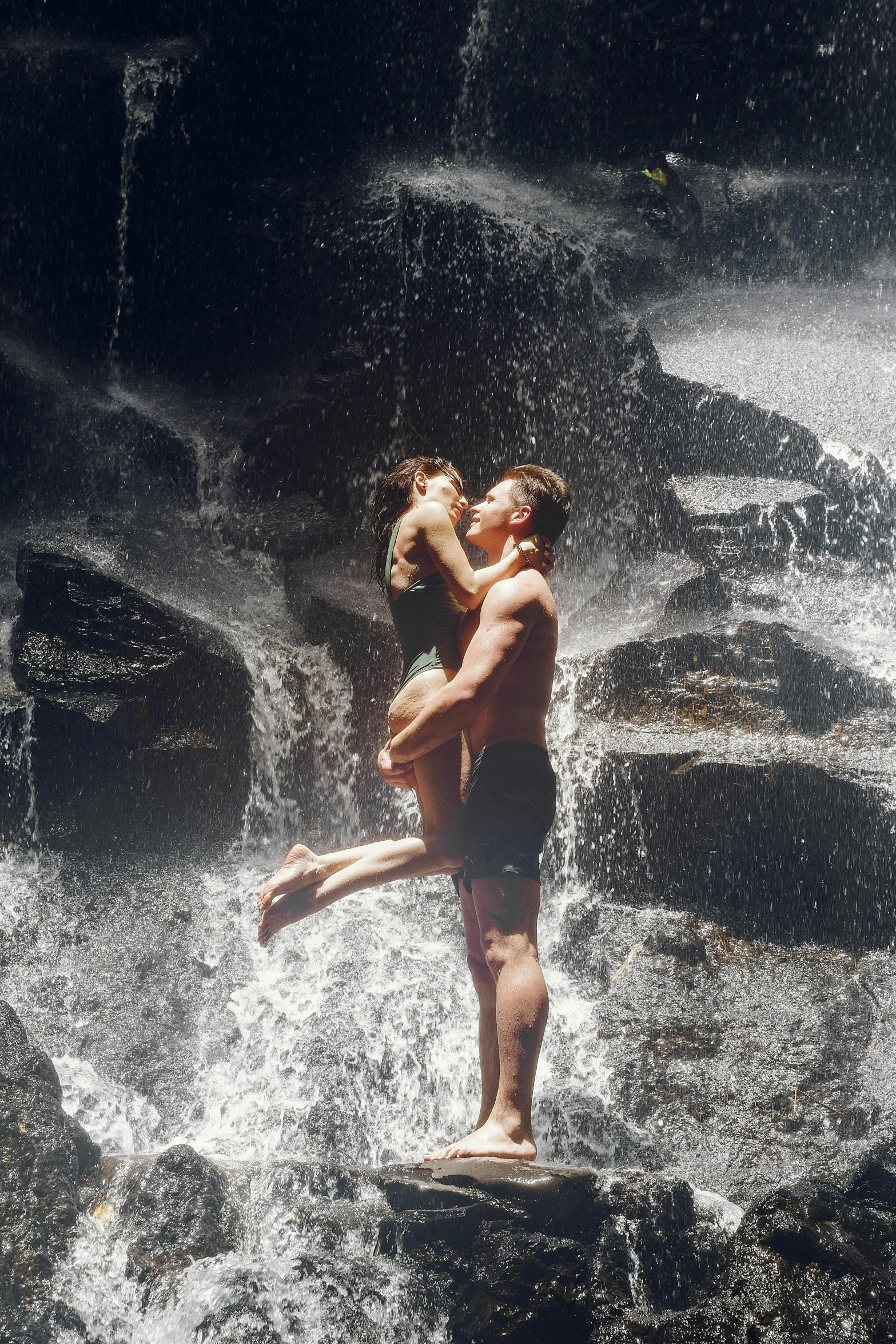 a man and a woman standing in front of a waterfall, ryan mcginley, swimming, on a hot australian day, kissing