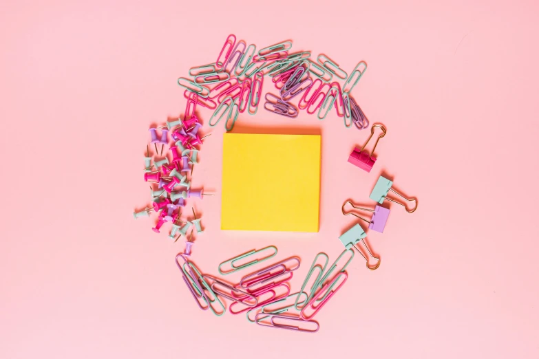 a yellow piece of paper surrounded by paper clips on a pink background, with a bunch of stuff, 15081959 21121991 01012000 4k, various items, professional product photo