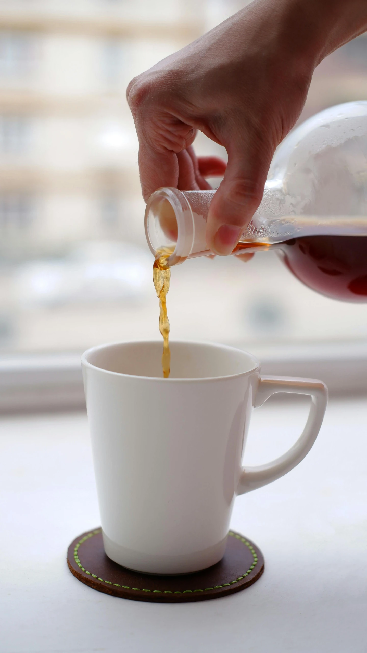 a person pouring a cup of coffee in front of a window, by Robbie Trevino, drinking cough syrup, detail shot, hero shot, in 2 0 1 5