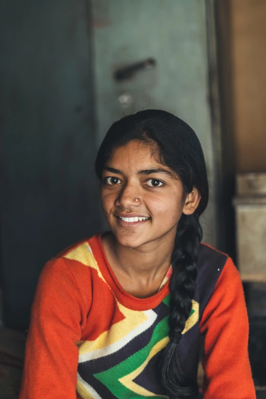 a woman sitting on a bed in a room, pexels contest winner, hurufiyya, from slumdog millionaire, smiling girl, profile portrait, full frame shot