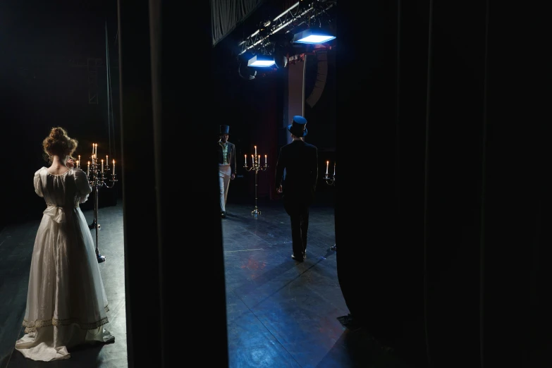 a couple of people that are standing in a room, by Elsa Bleda, romanticism, footage of a theater stage, behind the scenes photo