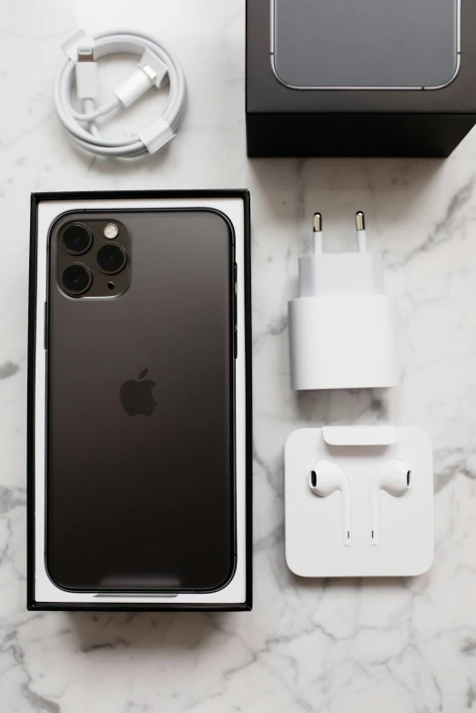 an iphone sitting on top of a table next to a charger, by Jens Søndergaard, hyperrealism, all black matte product, !! looking at the camera!!, 2 5 6 x 2 5 6, taken on iphone 14 pro