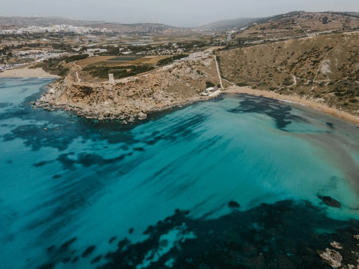 a large body of water next to a beach, pexels contest winner, les nabis, sapphire waters below, greek, thumbnail, hziulquoigmnzhah