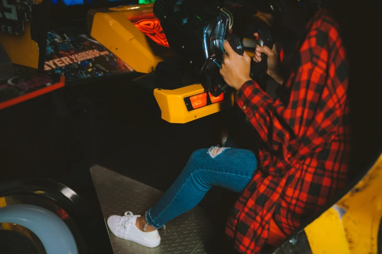 a woman in a plaid shirt playing a video game, inspired by Elsa Bleda, pexels contest winner, les automatistes, bumper cars, avatar image, head straight down, 1980s arcade