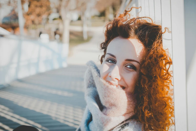 a woman with red hair posing for a picture, trending on pexels, happening, sunny winter day, brown curly hair, lovingly looking at camera, uploaded