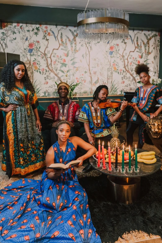 a group of people sitting around a table with candles, an album cover, by Ella Guru, wearing an african dress, pr shoot, unedited, high quality photo