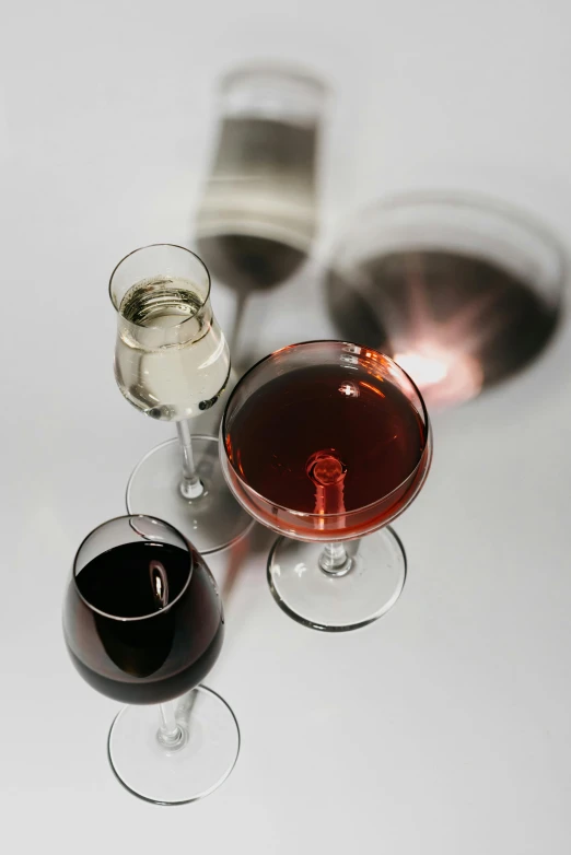 three glasses of wine sitting next to each other, by Carey Morris, highly polished, mirrored, mixing drinks, but minimalist