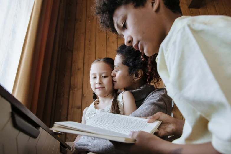 a woman reading a book to two young girls, pexels, figuration libre, a wooden, looking across the shoulder, varying ethnicities, a handsome