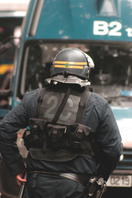 a police officer standing in front of a bus, by Adam Marczyński, reddit, french special ops, profile image, close-up photo, 2 people