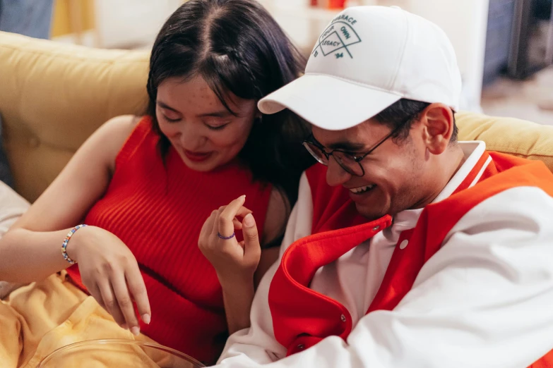 a man and a woman sitting on a couch, trending on pexels, red cap, ruan jia and brom, federation clothing, smiling couple