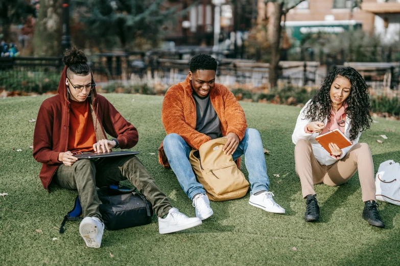 a group of people sitting on top of a lush green field, trending on pexels, happening, trying to study, in a city square, bags on ground, nerds