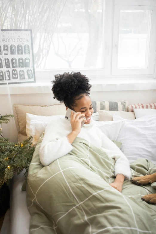 a woman laying in bed talking on a cell phone, trending on pexels, seasonal, essence, tall, covered with blanket