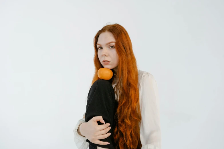 a woman with long red hair holding an orange, inspired by Sarah Lucas, trending on pexels, renaissance, on a white background, bella poarch, high quality photo, coral