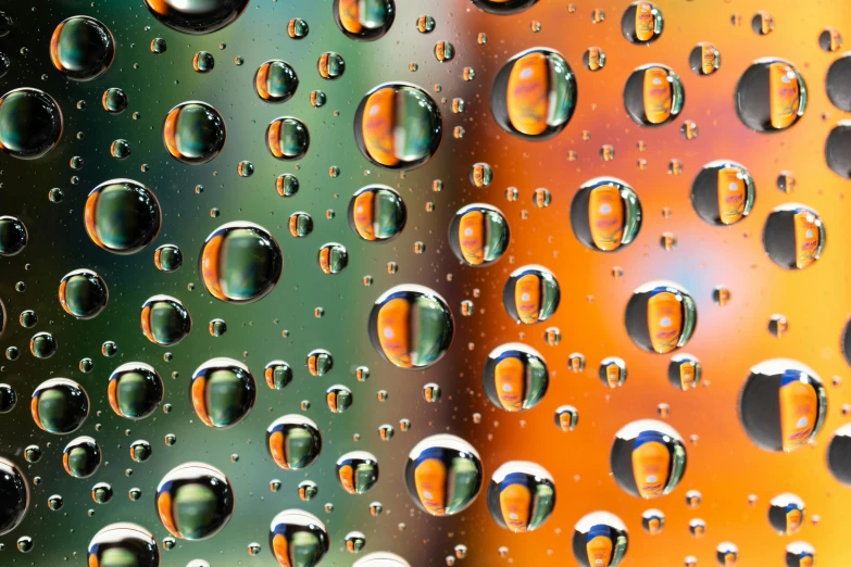 a close up of water droplets on a window, a macro photograph, by Jan Rustem, hyperrealism, orange and teal color, ray tracing reflections, photo realistic image, multicoloured