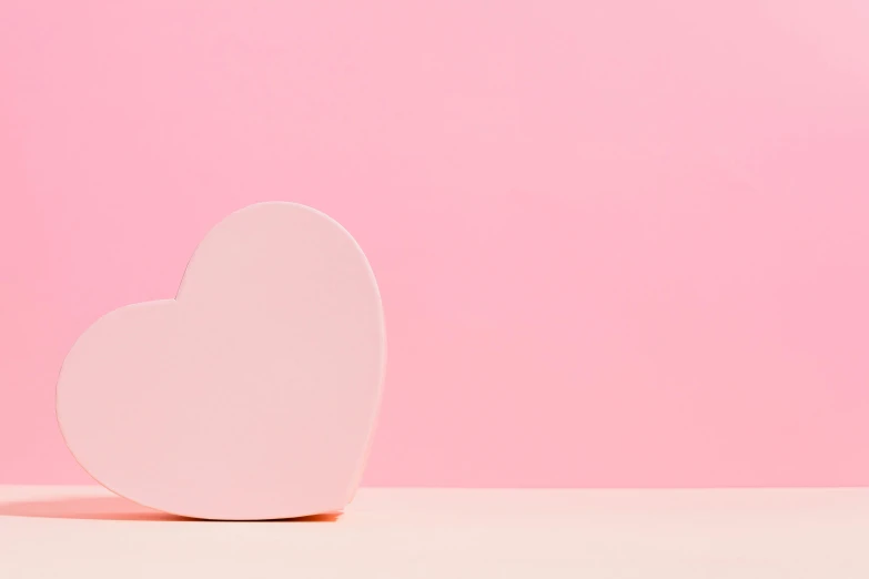 a white heart on a pink background, trending on unsplash, minimalism, background image, chocolate, clemens ascher, set photo