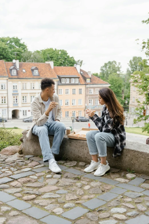 a couple of people that are sitting on a ledge, eating outside, ewa juszkiewicz, having a snack, talking