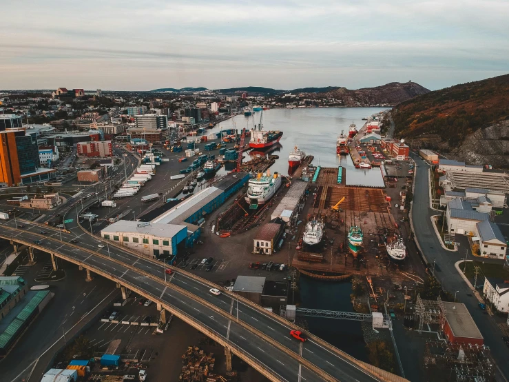 a harbor filled with lots of boats under a cloudy sky, by Brian Snøddy, pexels contest winner, drone view of a city, shipyard, worksafe. instagram photo, bridges