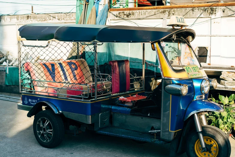 a tuk - tuk is parked on the side of the road, trending on unsplash, square, blue and orange color scheme, thai, fantastic vendor interior