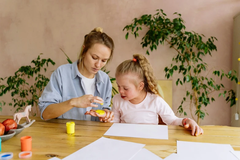 a woman and a little girl sitting at a table, pexels contest winner, glue dropping, low quality photo, thumbnail, 1 2 9 7