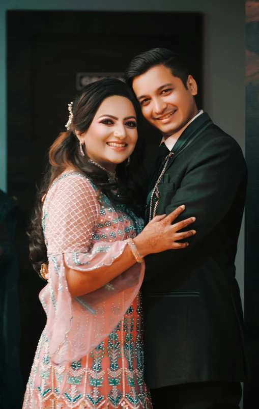 a man and a woman standing next to each other, an album cover, pexels, hurufiyya, elegant smiling pose, indian, gif, portrait n - 9