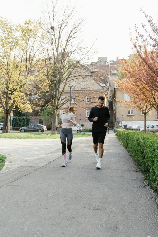 a couple of people that are running in the street, by Matija Jama, renaissance, in a city park, influencer, mid body, hungarian