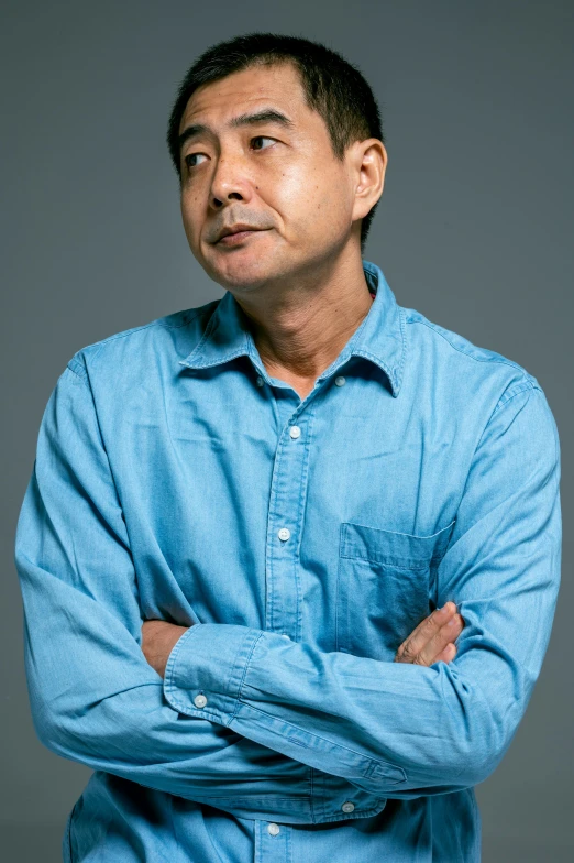 a man in a blue shirt standing with his arms crossed, inspired by Yasushi Sugiyama, promotional image, headshot photograph, junji murakami, promotional photograph