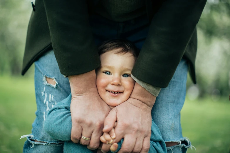 a close up of a person holding a child, by Nina Hamnett, pexels contest winner, fun pose, husband wife and son, conor walton, various posed