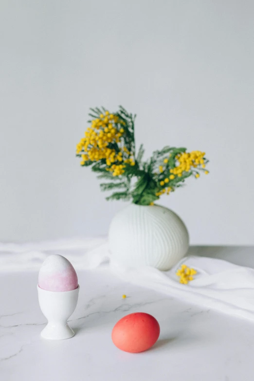two eggs and a vase of flowers on a table, a marble sculpture, inspired by Jeff Koons, unsplash, minimalism, candy decorations, studio shot, holiday season, smooth porcelain skin