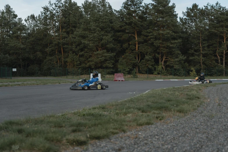 a person riding a motorcycle on a race track, during the night, buggy, forrest in the background, guillaume tholly