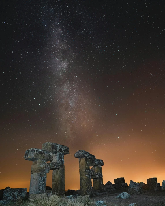 a group of stonehenks sitting on top of a hill under a night sky filled with stars, by Andrew Allan, pexels contest winner, renaissance, monolithic temple, stone colossus remains, statue of a cubes and rings, photograph of april