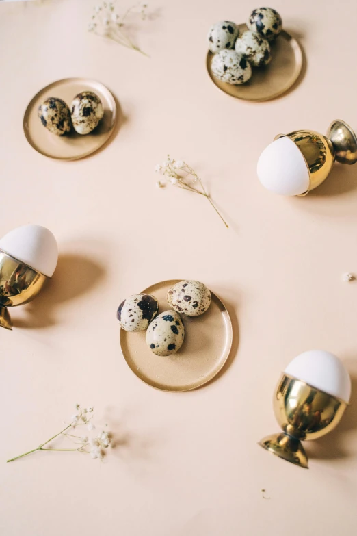 a bunch of eggs sitting on top of a table, trending on unsplash, baroque, metallic brass accessories, white with black spots, lighthearted celebration, thumbnail