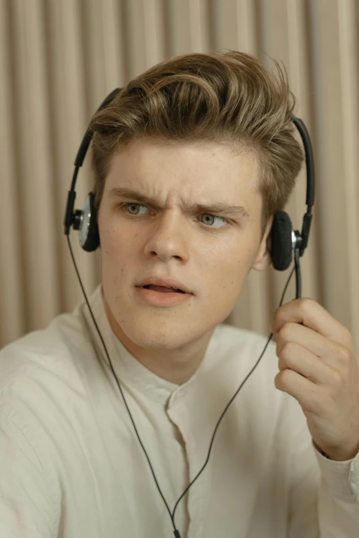 a close up of a person wearing headphones, an album cover, inspired by Caspar Wolf, realism, leaked photo, frustrated expression, commercial photo, hyperreal movie shot