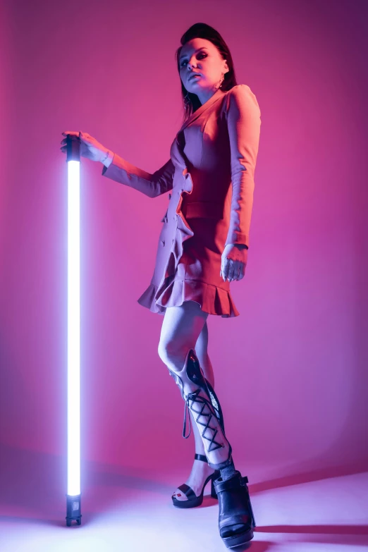 a woman standing next to a light saber, inspired by David LaChapelle, thighhighs and skirt, barely lit warm violet red light, highkey lighting, neon colored dress