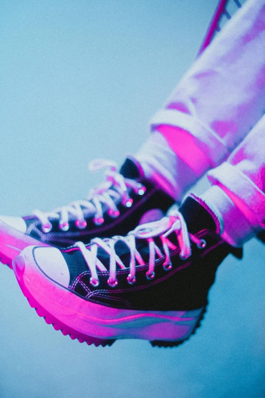 a pair of black sneakers with pink laces, an album cover, inspired by Elsa Bleda, trending on pexels, aestheticism, vibrant lights, teenage boy, high - contrast, raver