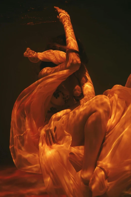 a woman in a white dress is in the water, an album cover, inspired by Anna Füssli, arabesque, coloured in orange fire, diaphanous iridescent silks, showstudio, detail shot