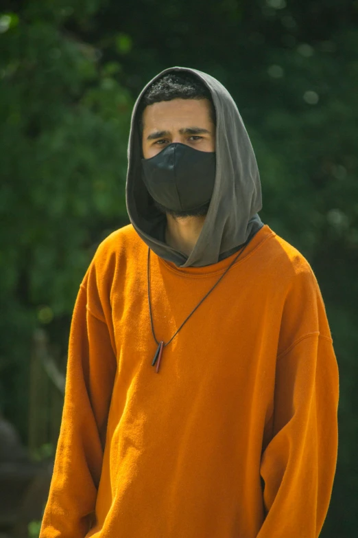 a man in an orange shirt and a black mask, wearing a hoody, streetwear, h3h3, environment