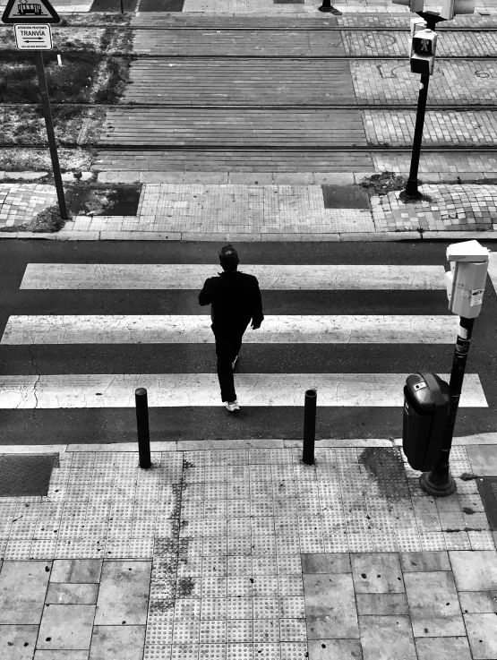 a black and white photo of a man walking across a crosswalk, a black and white photo, by Constantine Andreou, bird\'s eye view, run for your life, black! and white colors, square