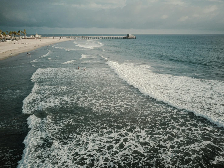 a large body of water next to a beach, by Carey Morris, unsplash contest winner, photorealism, on a gray background, oceanside, taken in the 2000s, trending on vsco