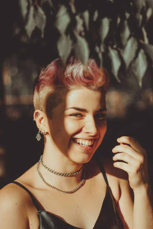 a woman with pink hair smiling at the camera, inspired by Elsa Bleda, pixie cut, grainy photo, mutahar laughing, promo image