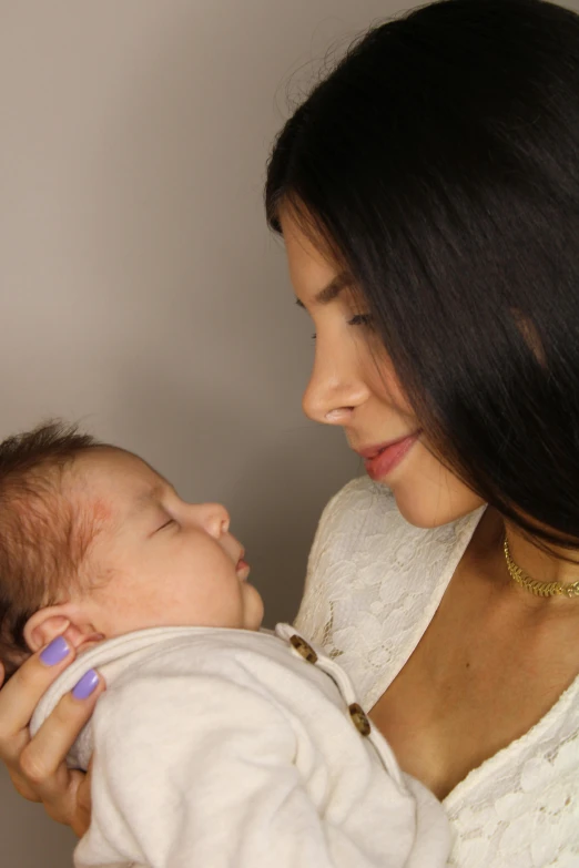 a woman holding a baby in her arms, madison beer, cleft chin, diffused natural skin glow, 4k)