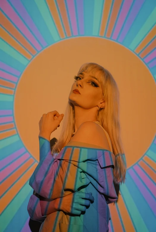 a woman standing in front of a colorful background, an album cover, by Jessie Alexandra Dick, holography, pale hair, christian saint, orange and cyan lighting, doing a hot majestic pose