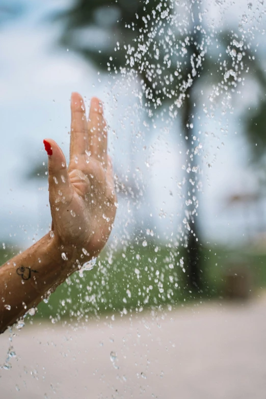 a woman's hand is sprinkled with water, pexels contest winner, saluting, promo image, calm weather, full frame image